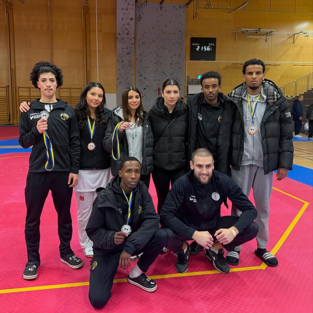 En grupp taekwondoutövare från klubben efter SM 2025 poserar i hallen med sina medaljer, fyra silver och två brons, efter säsongens sista tävling.